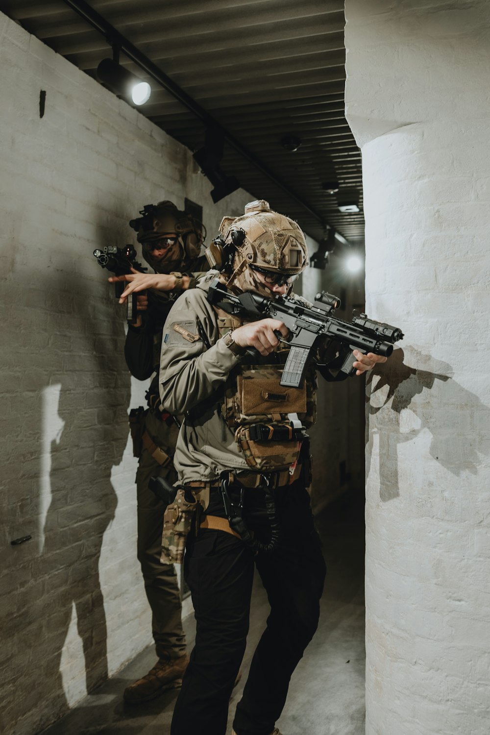 a man holding a gun while standing next to another man