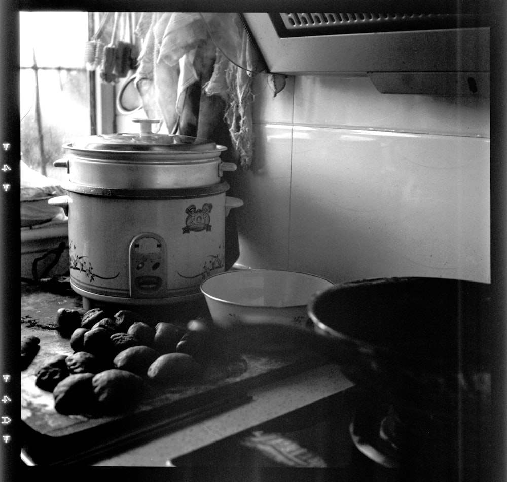 a black and white photo of a kitchen with a pot on the stove