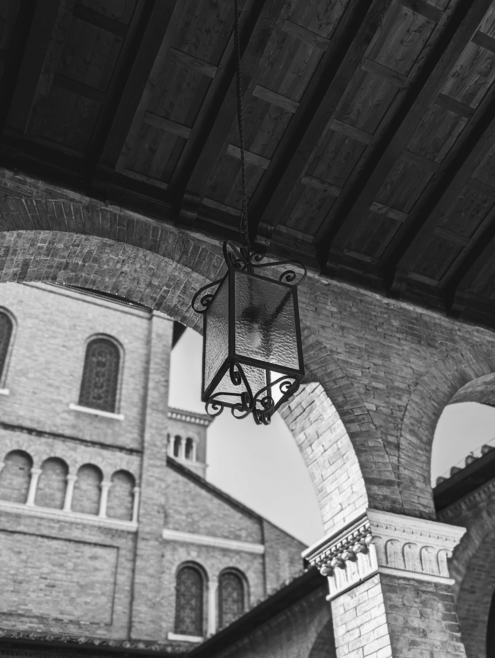 a black and white photo of a light hanging from a ceiling