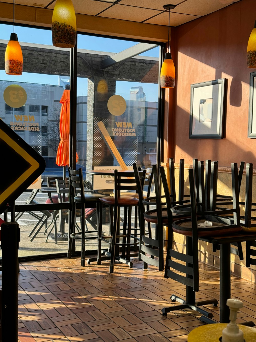 a restaurant with tables, chairs and an umbrella