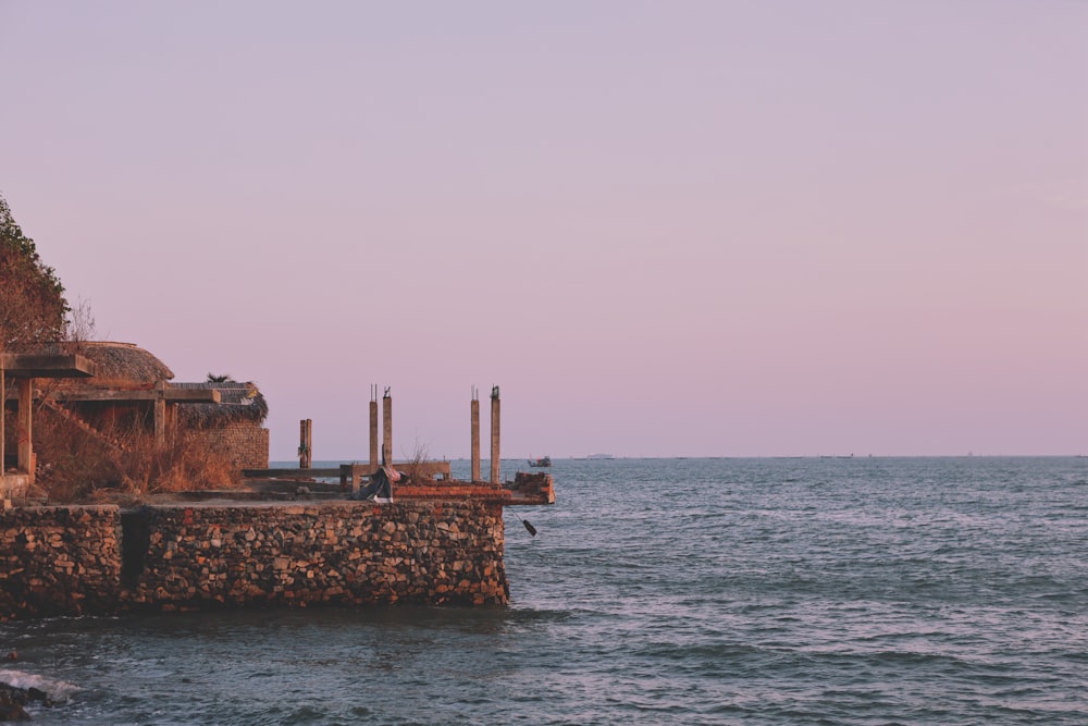 a body of water next to a stone wall