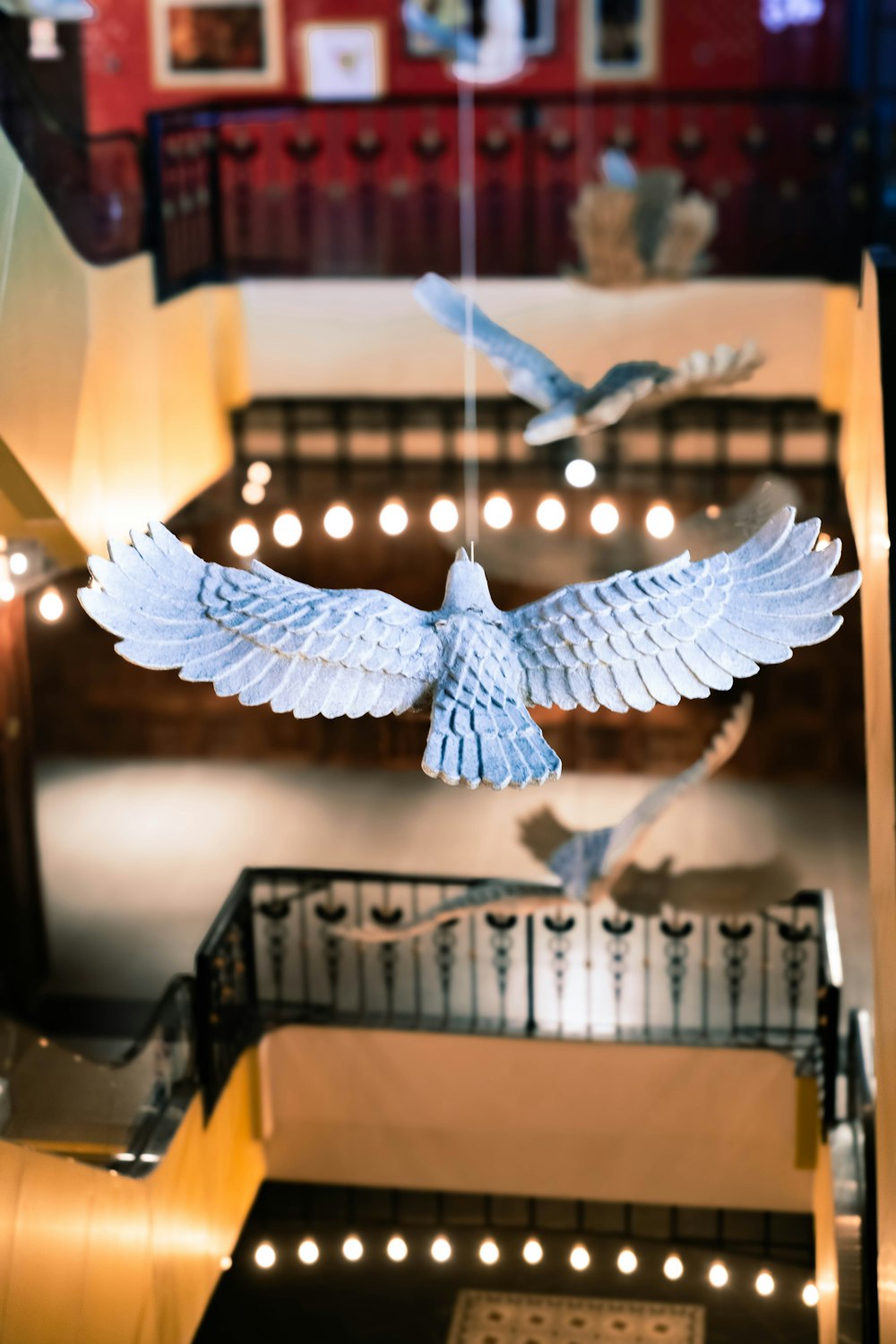 a white bird flying over a stairwell in a building