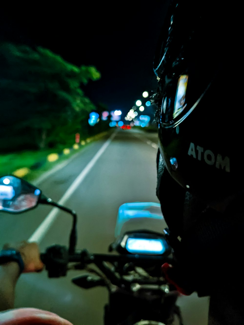 a person riding a motorcycle down a street at night