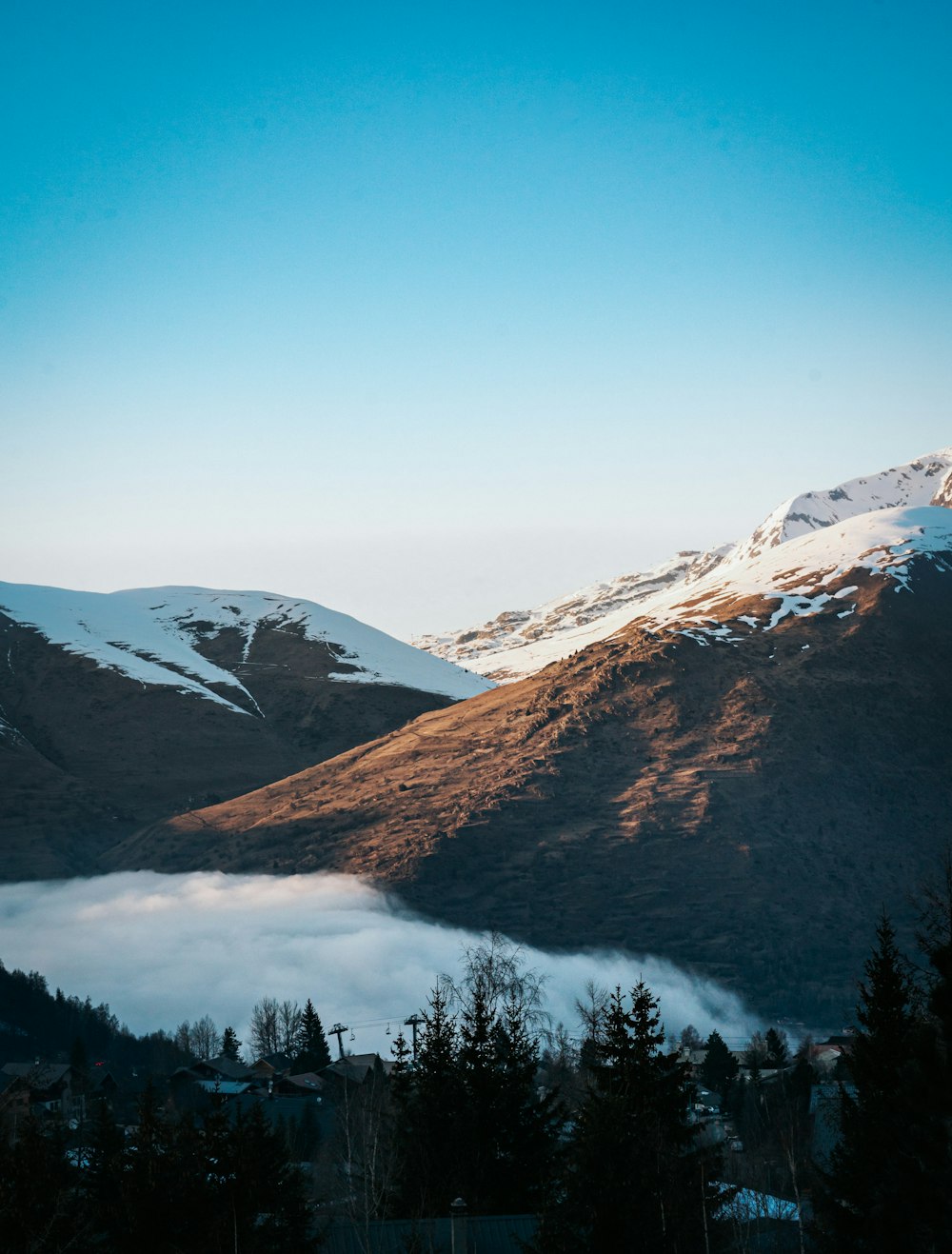 Blick auf ein Gebirge mit tiefhängenden Wolken im Vordergrund