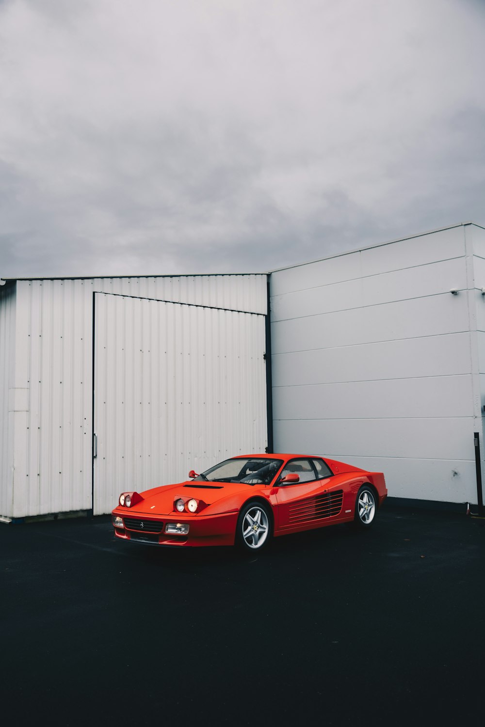 a red sports car parked in front of a white building