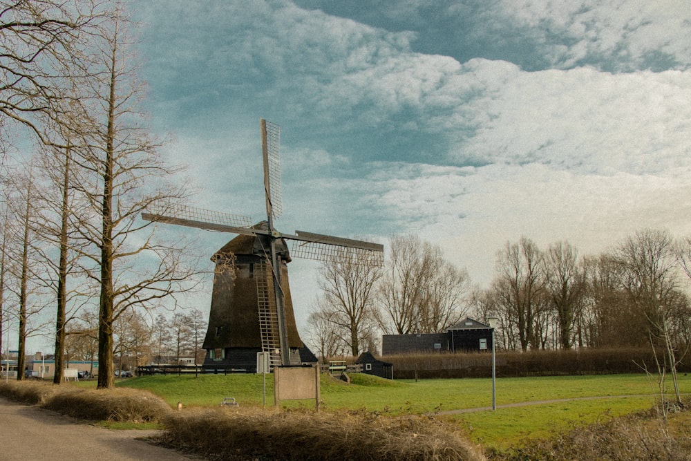 a windmill in the middle of a grassy field