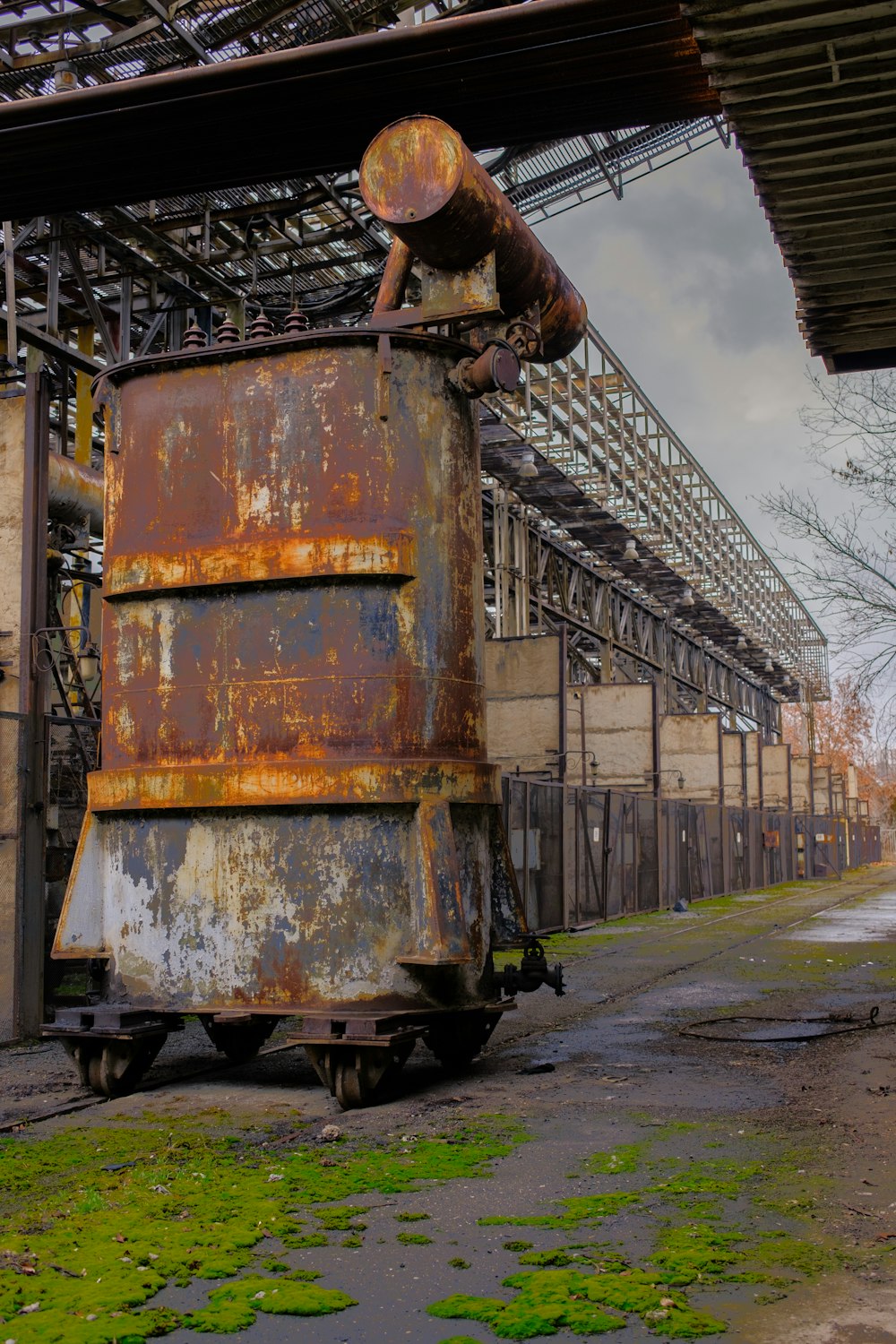 a rusted out train car sitting in front of a building