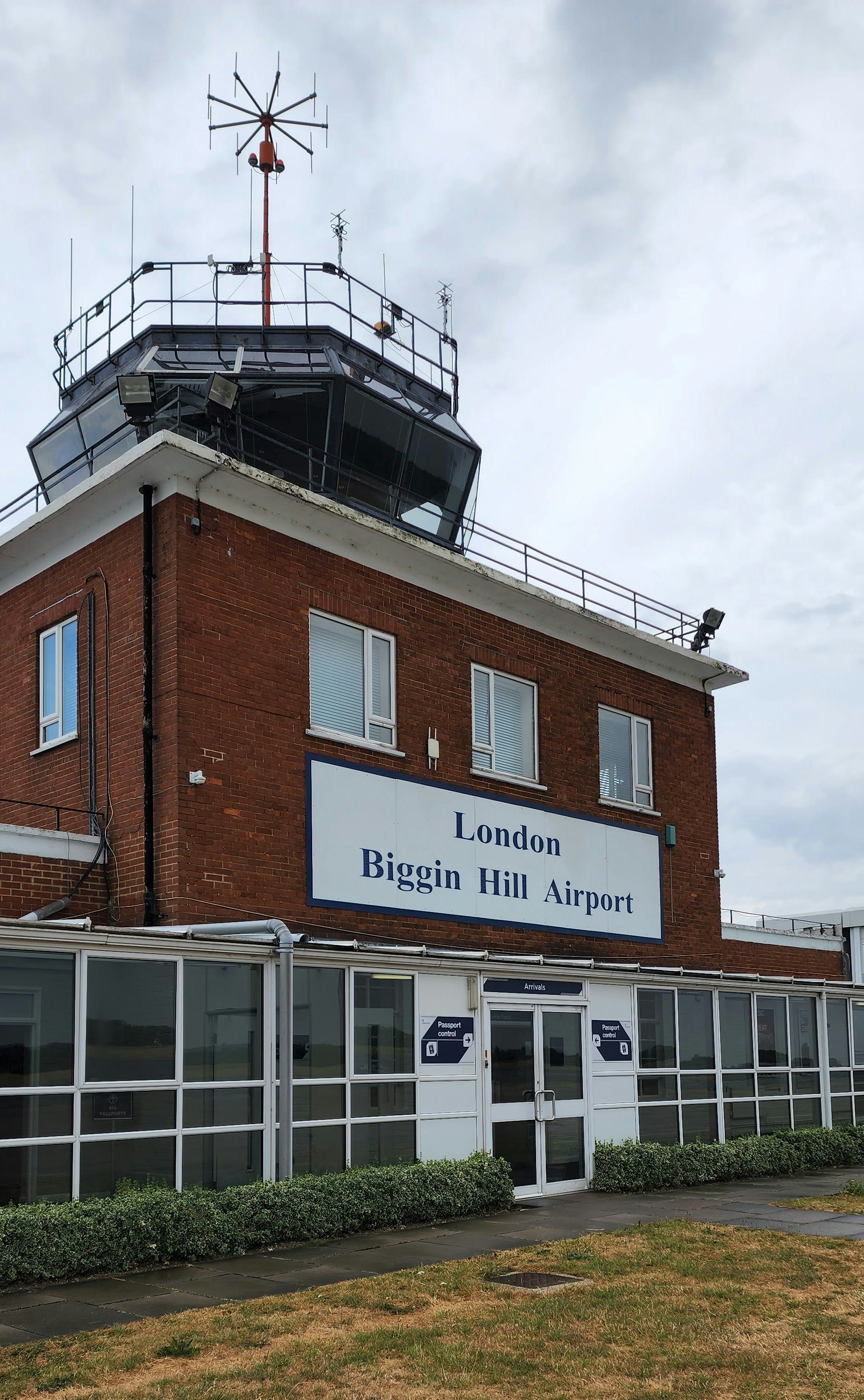 a tall red brick building with a weather vane on top of it