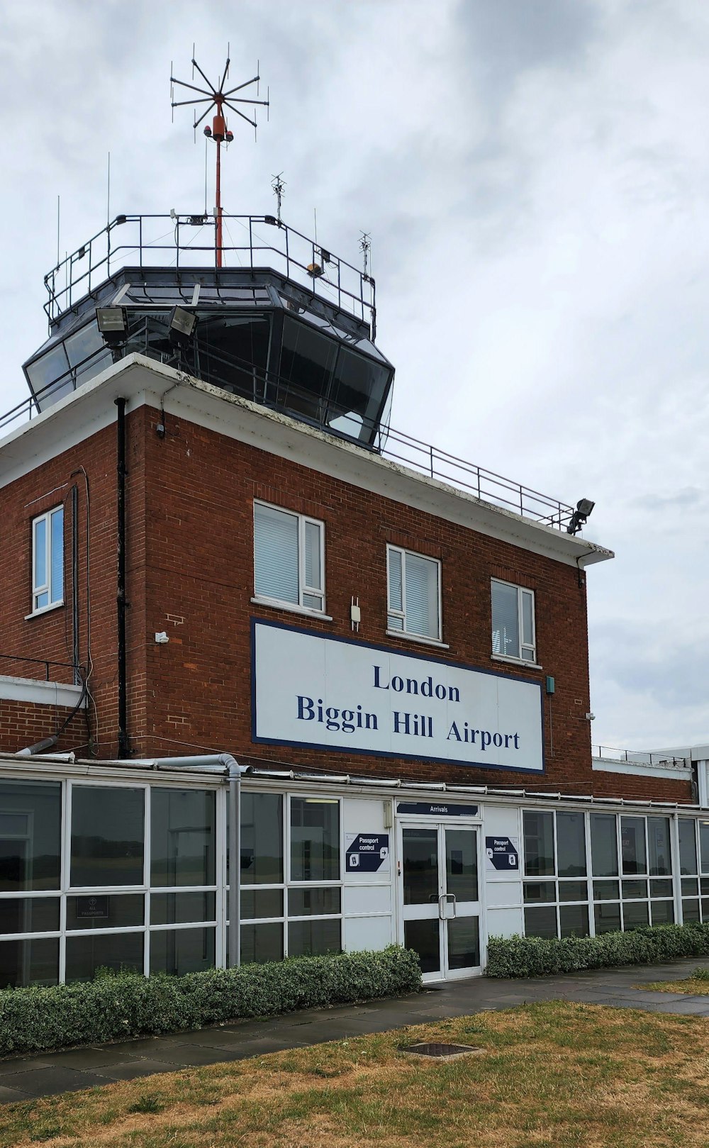 a tall red brick building with a weather vane on top of it