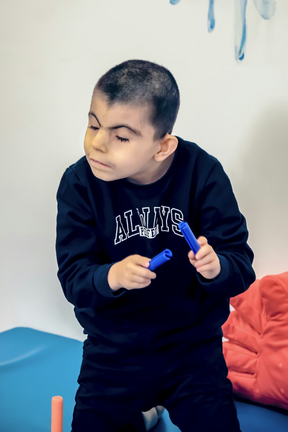 a young boy sitting on a bed holding a toothbrush