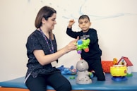a woman playing with a child on a table
