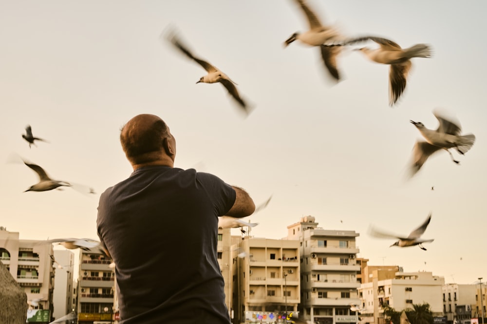a man standing in front of a flock of birds