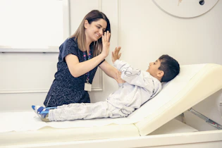a woman is giving a boy a high five