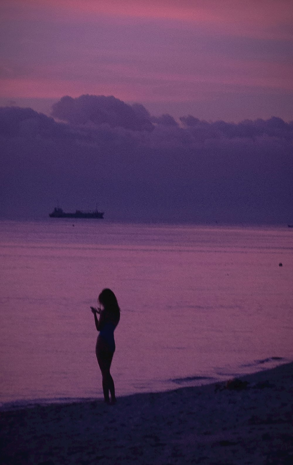 eine Frau, die auf einem Strand neben dem Meer steht