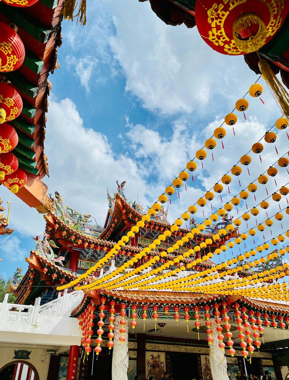 a group of yellow and red lanterns hanging from the ceiling