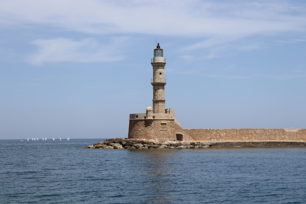 a light house sitting on the side of a body of water