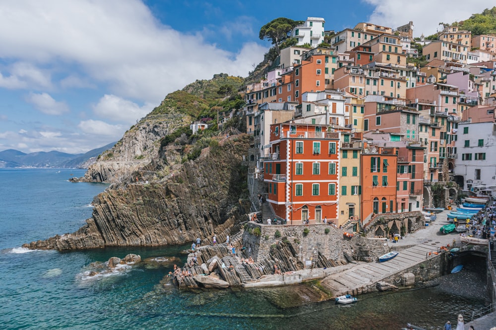 a group of buildings on a cliff above the water