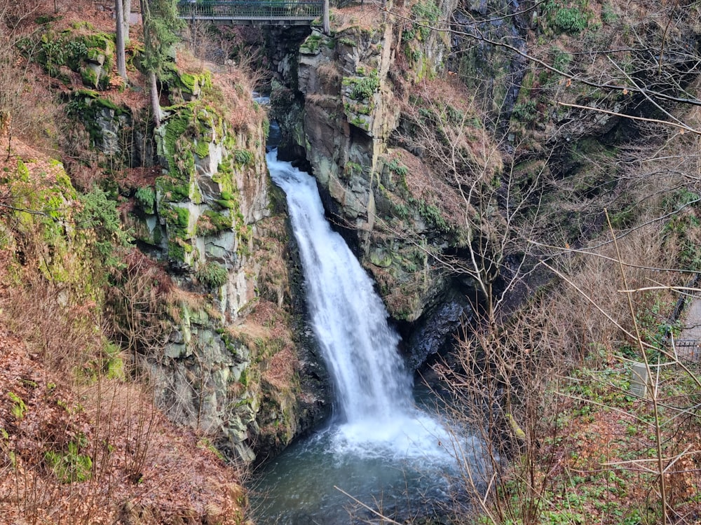 a waterfall with a bridge in the background