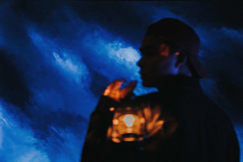 a man standing in front of a painting of a sky