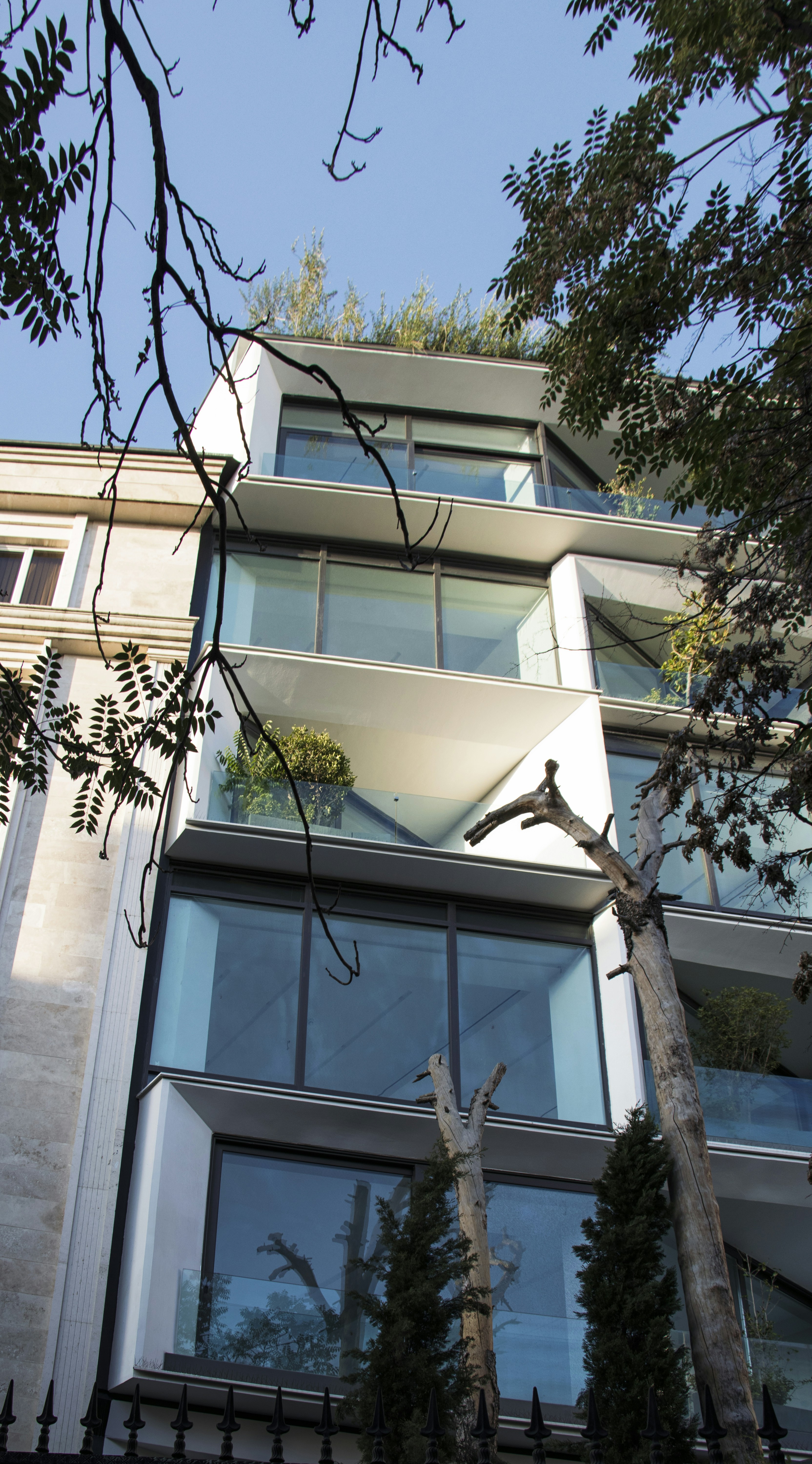 a tall building with lots of windows next to trees