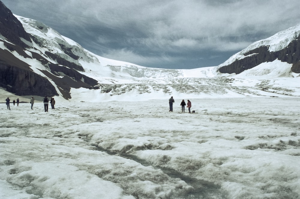 a group of people standing on top of a snow covered slope