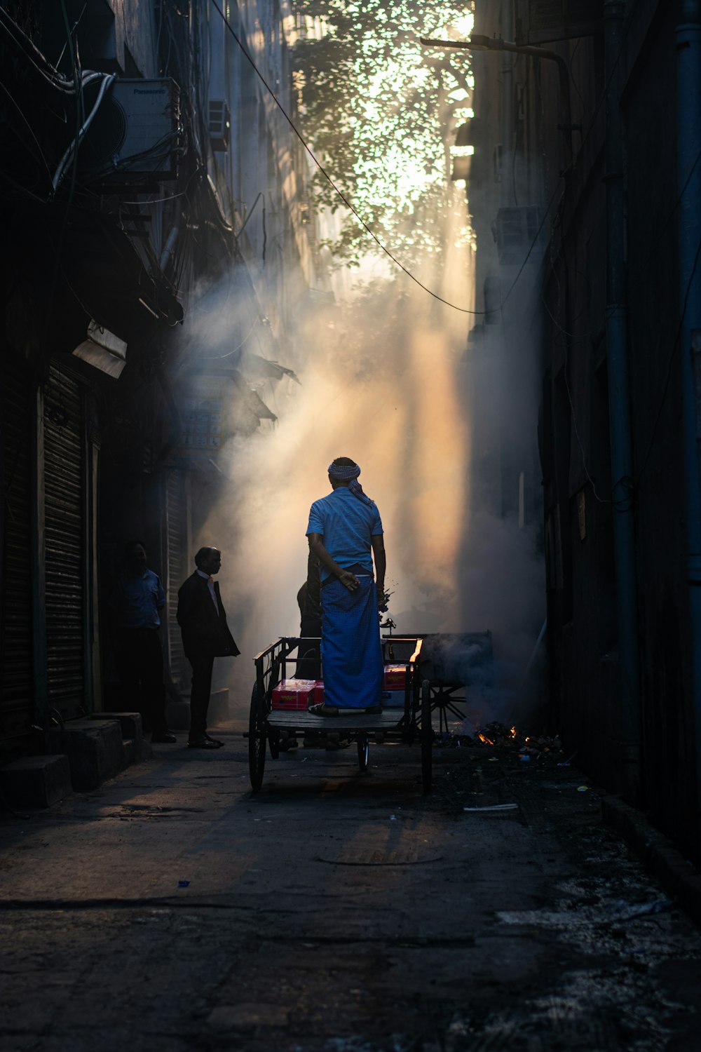 a man standing on a cart in the middle of a street