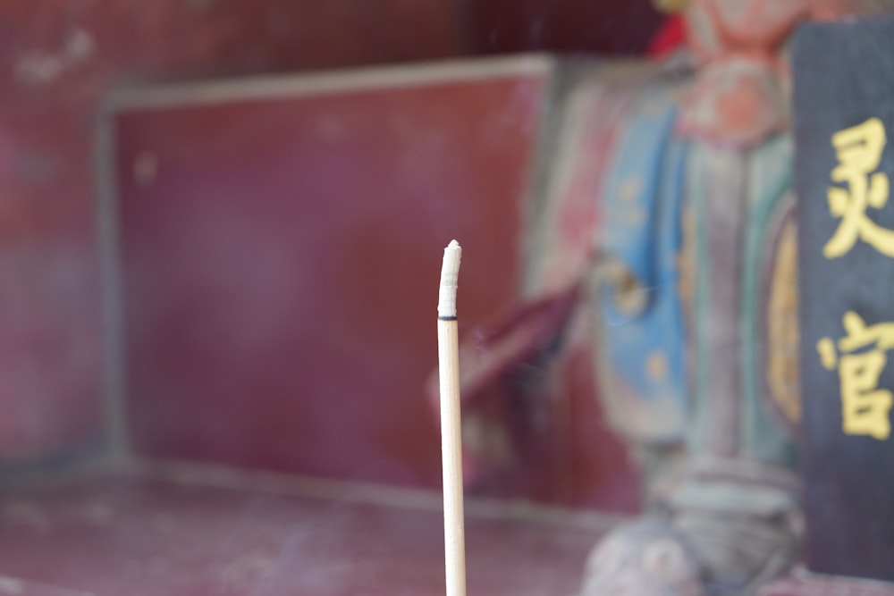 a white matchstick sitting on top of a table next to a book
