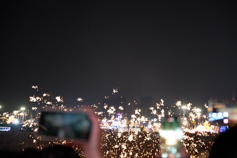 a person taking a picture of fireworks in the sky