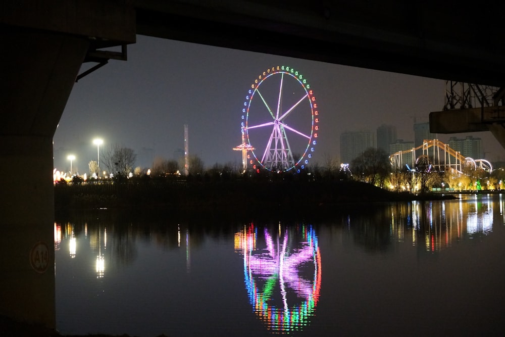 a ferris wheel is reflected in the water