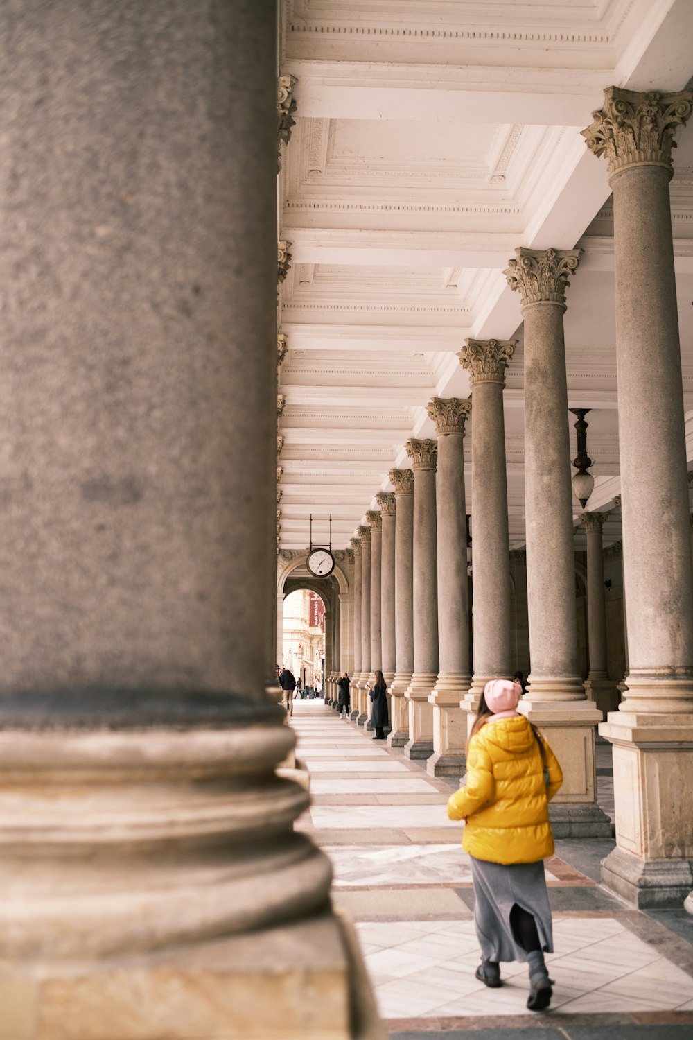 a person in a yellow jacket is walking down a walkway