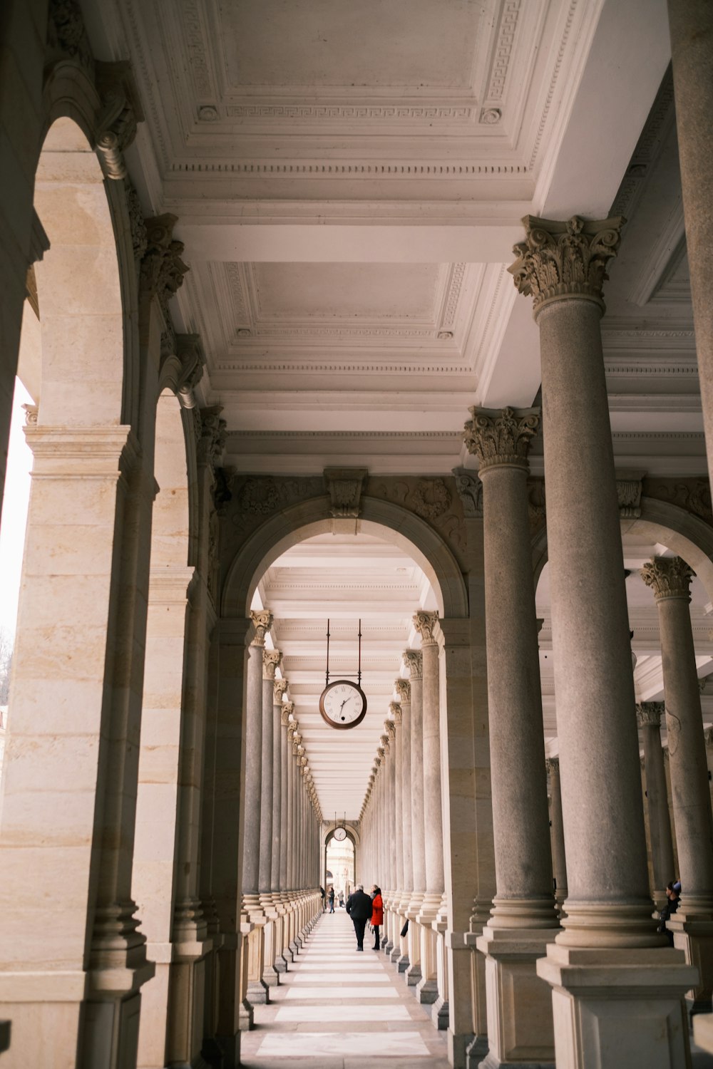 a couple of people walking down a long hallway