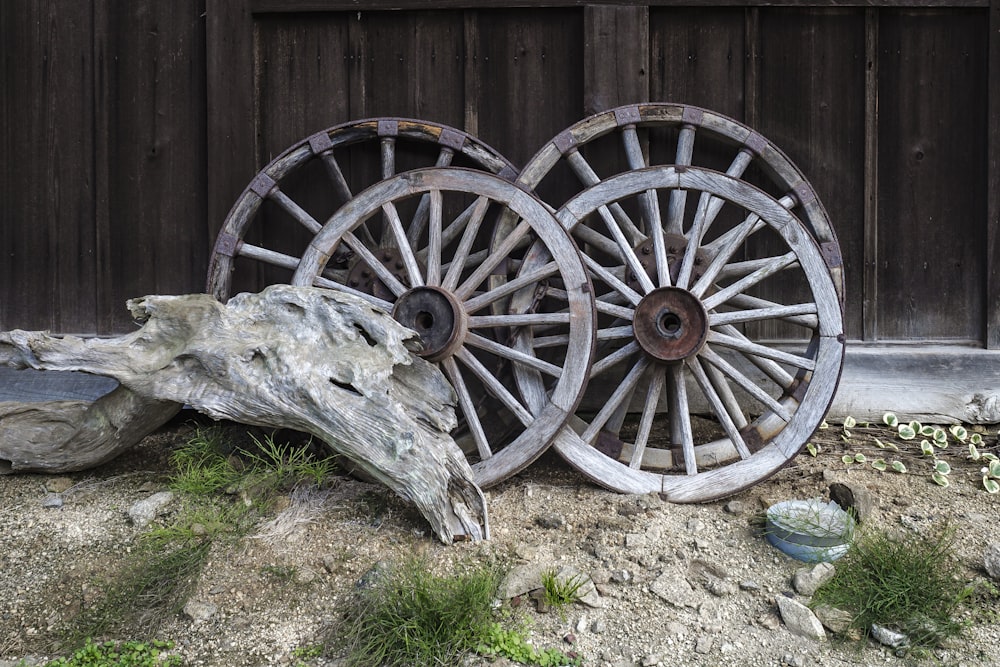 two old wooden wagon wheels sitting on the ground