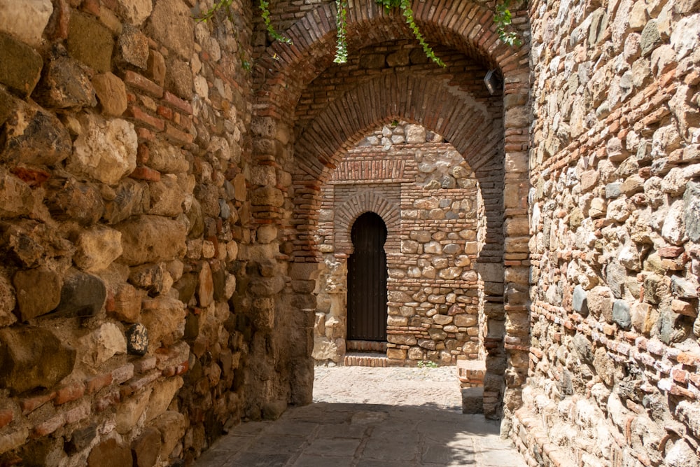 a narrow alley with a door and a brick wall
