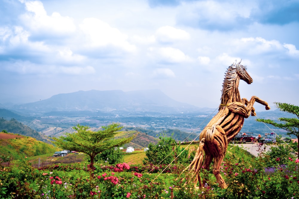 a statue of a horse in a field of flowers