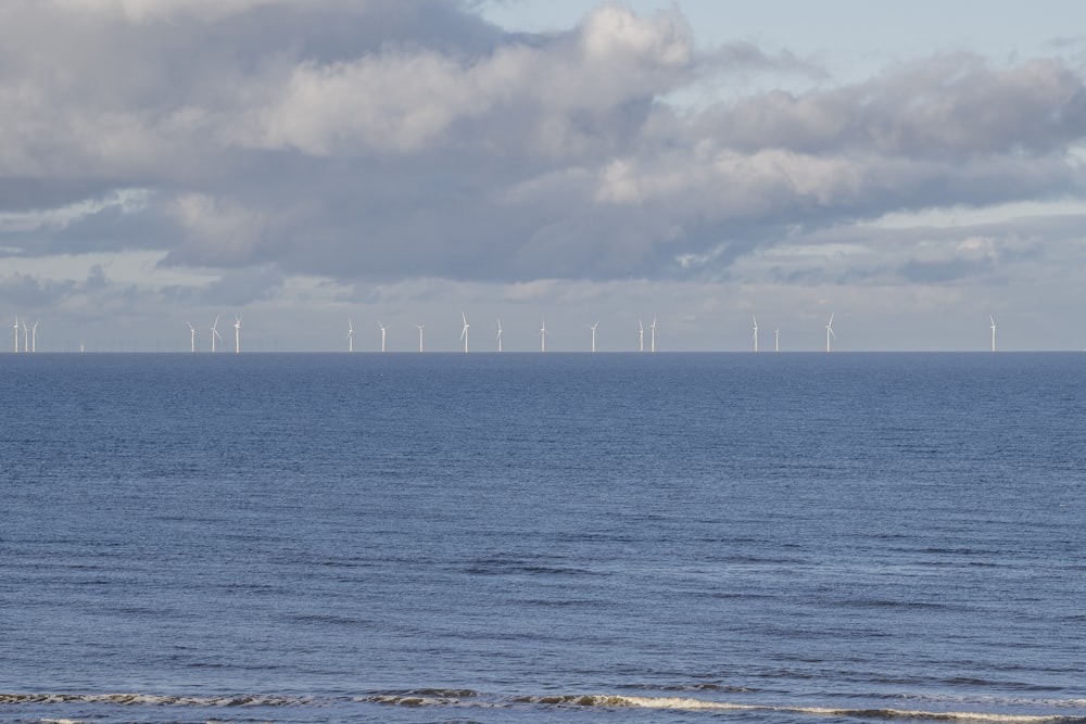 a large body of water with a bunch of wind mills in the distance