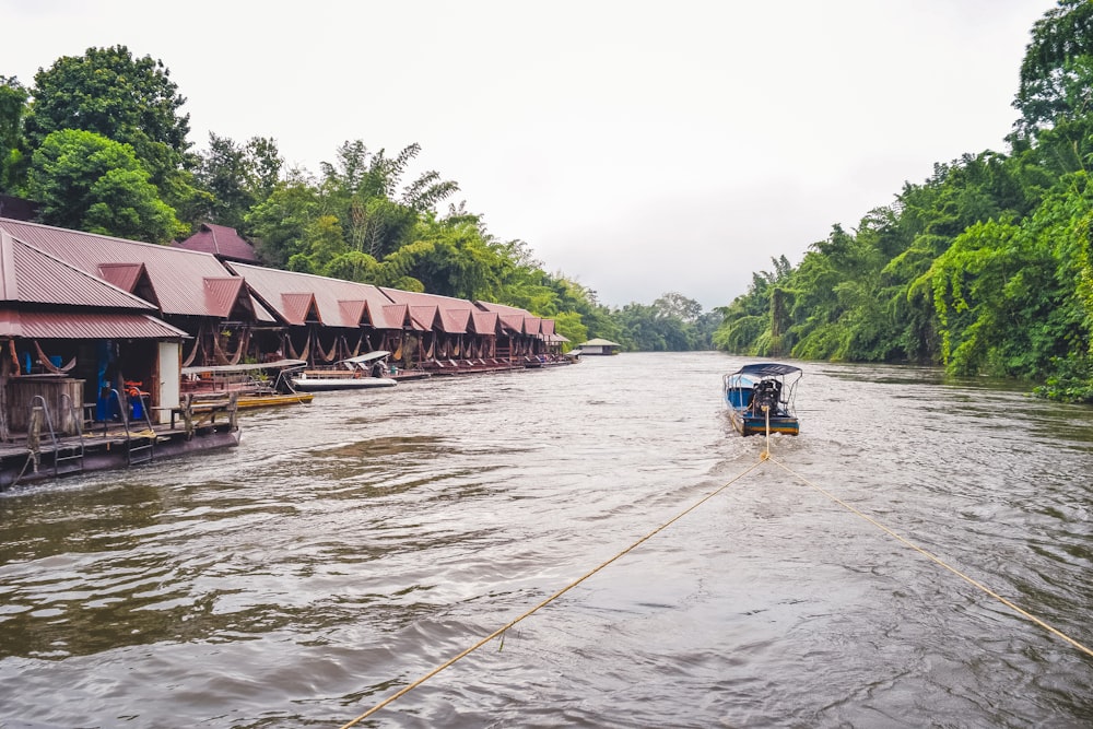 a boat traveling down a river next to a row of houses