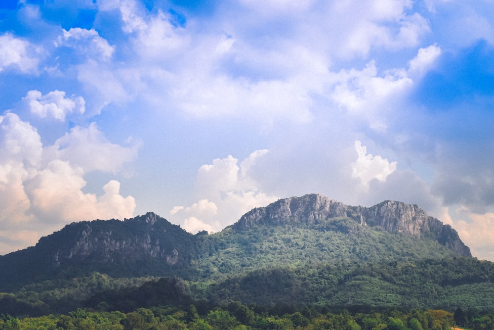 a large mountain with a few clouds in the sky