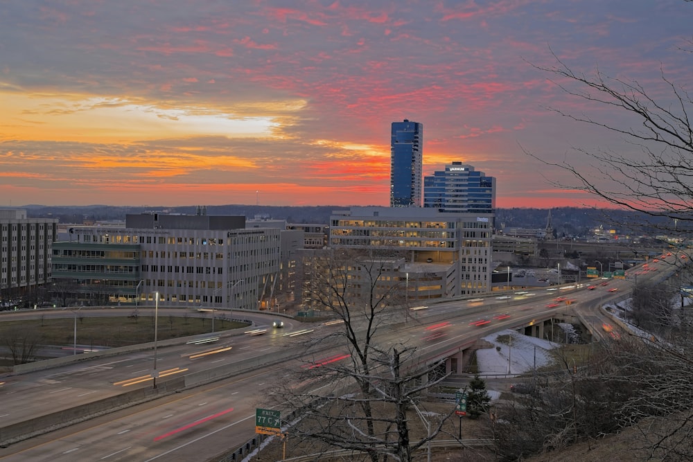 a view of a city at sunset from the top of a hill