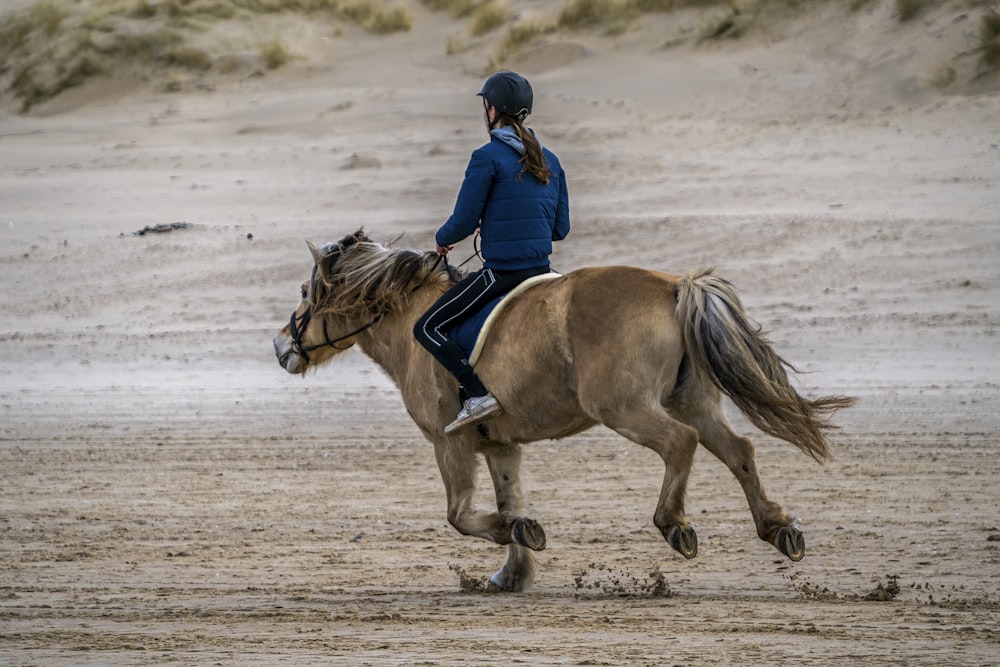 a woman riding on the back of a brown horse