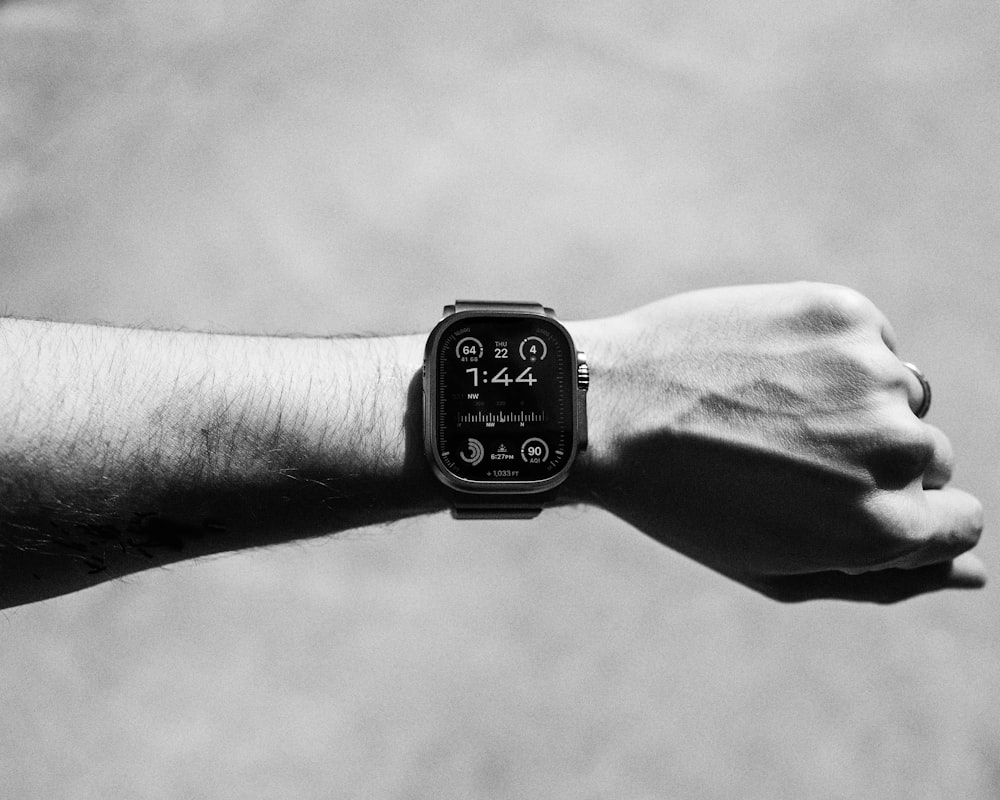 a black and white photo of a person's arm with a watch on it