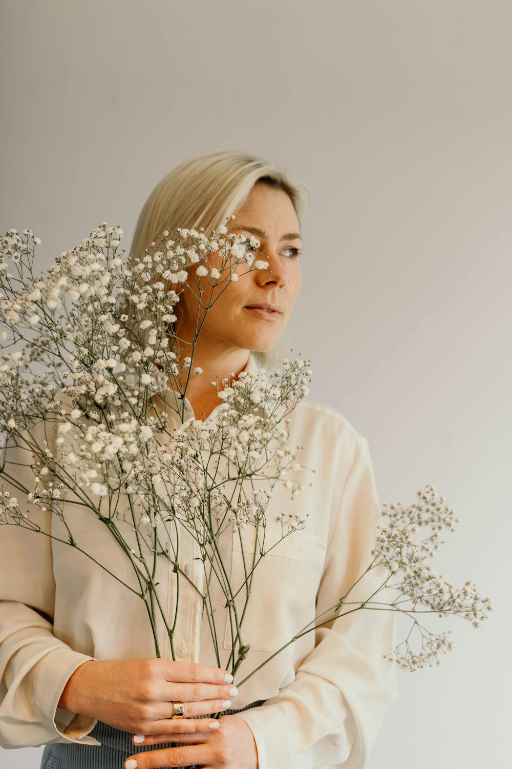 a woman holding a bunch of white flowers