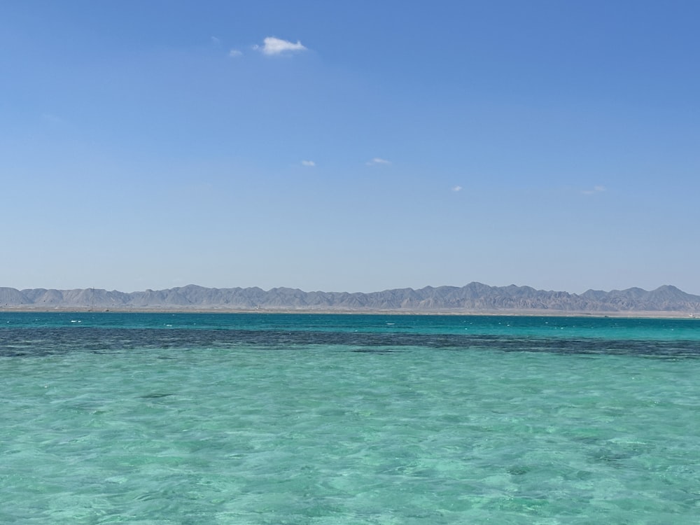 a large body of water with mountains in the background