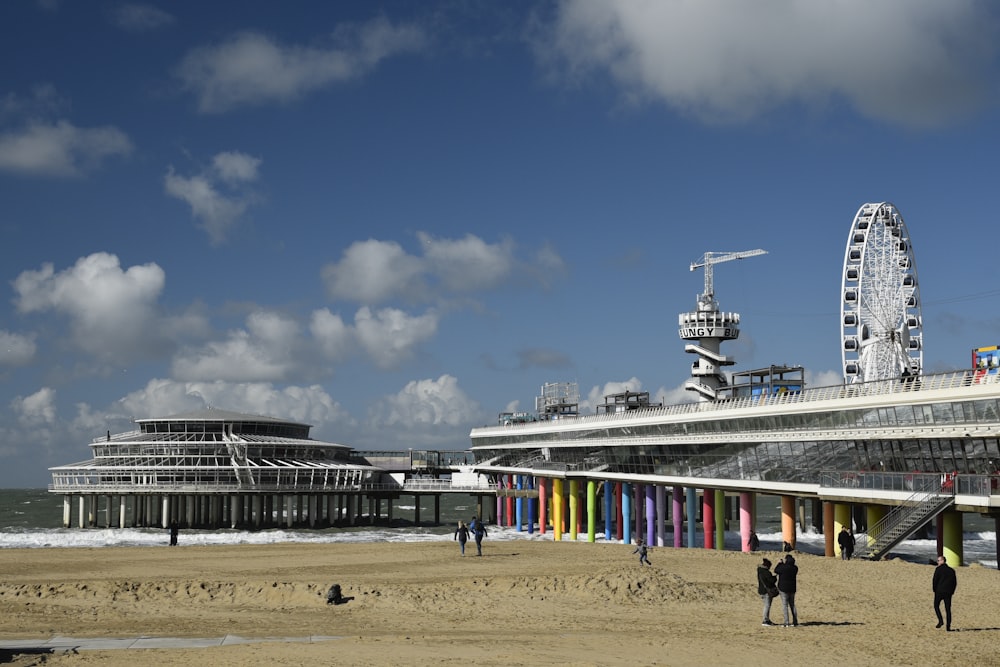 un groupe de personnes debout au sommet d’une plage de sable