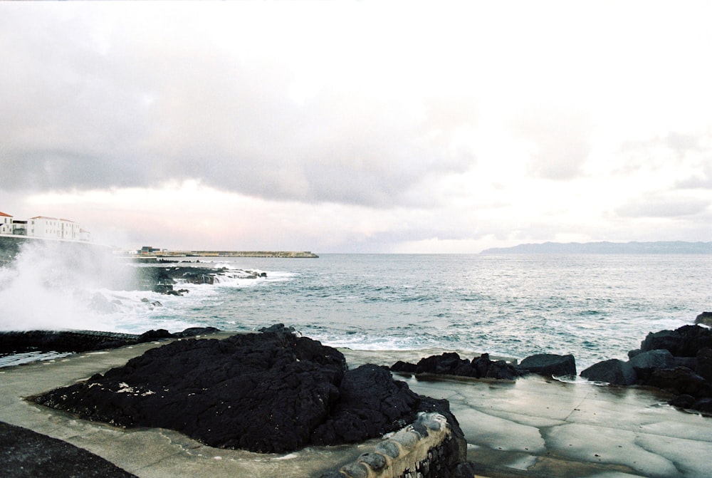 a large body of water next to a rocky shore