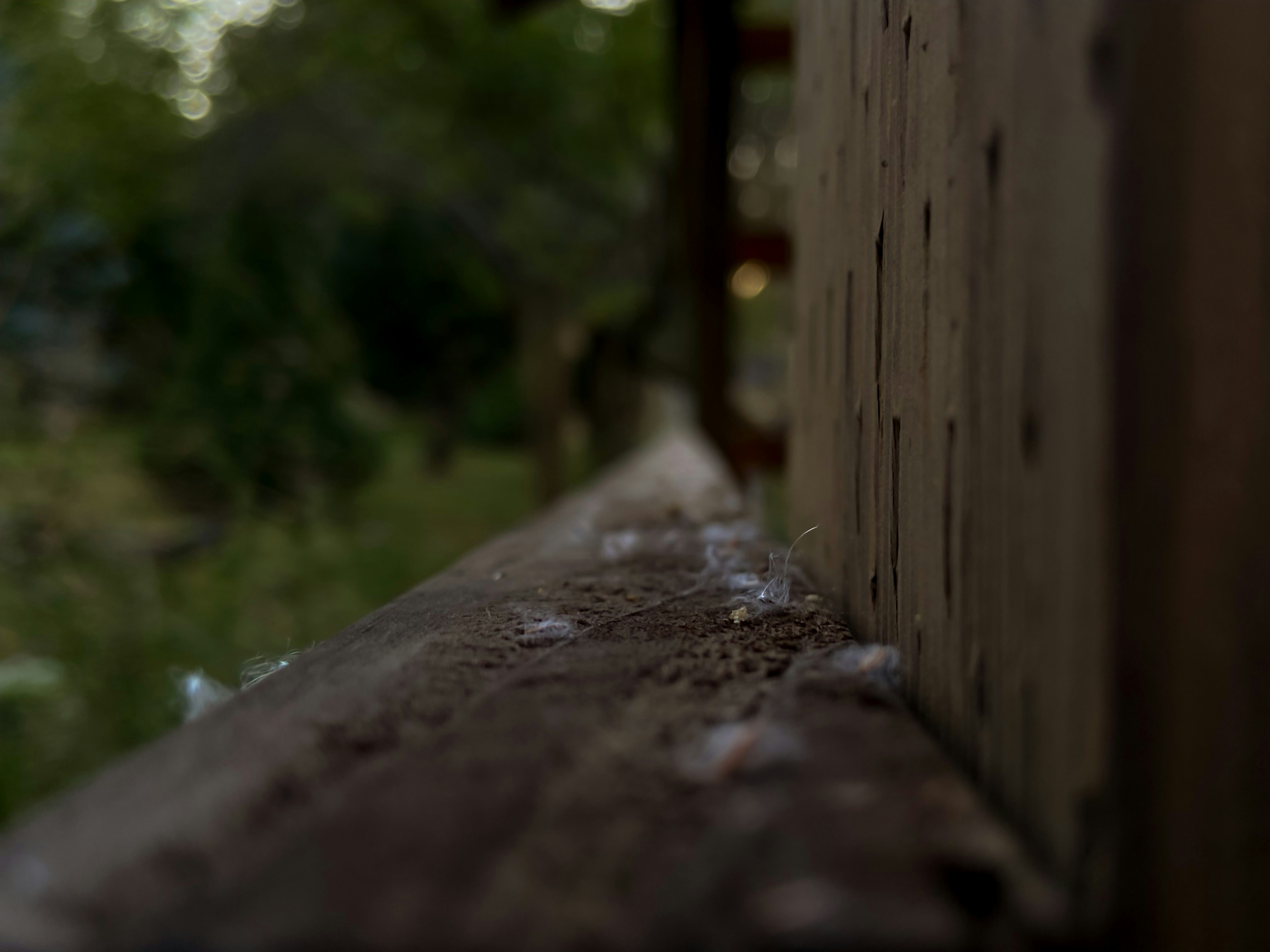a close up of a wooden ledge with a blurry background