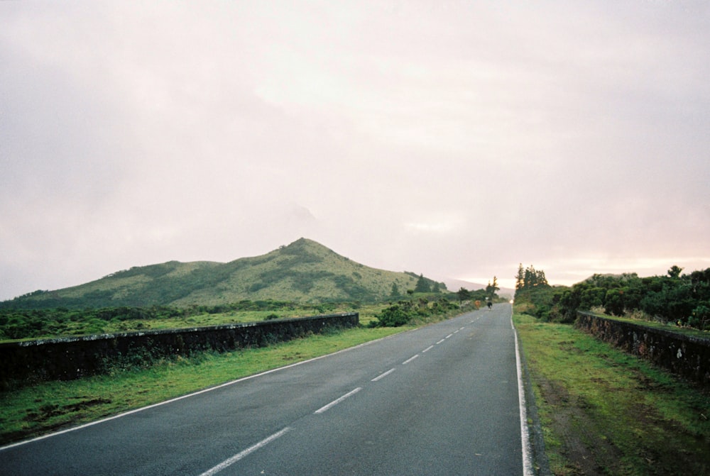 an empty road with a mountain in the background