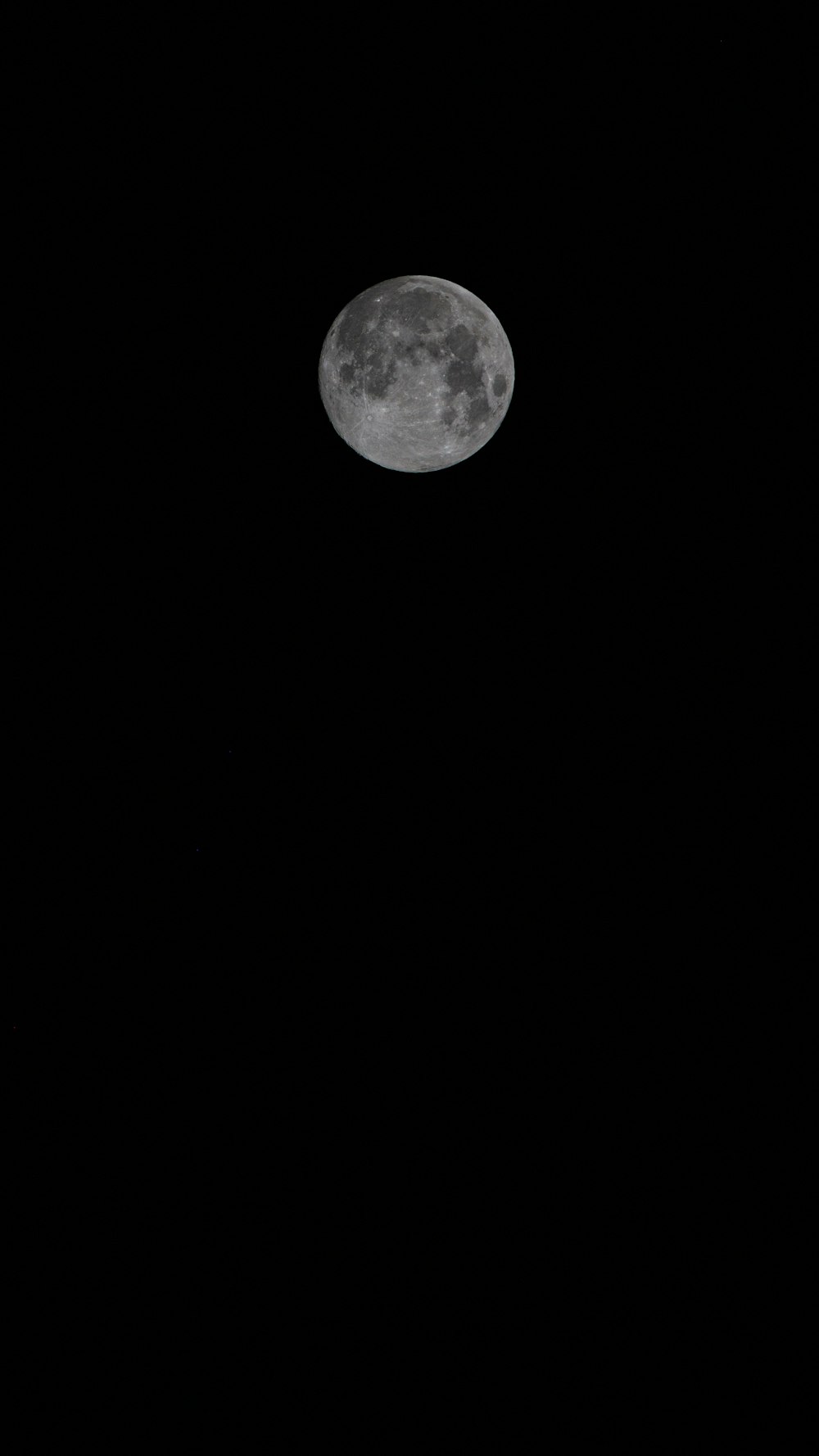 a full moon is seen in the dark sky