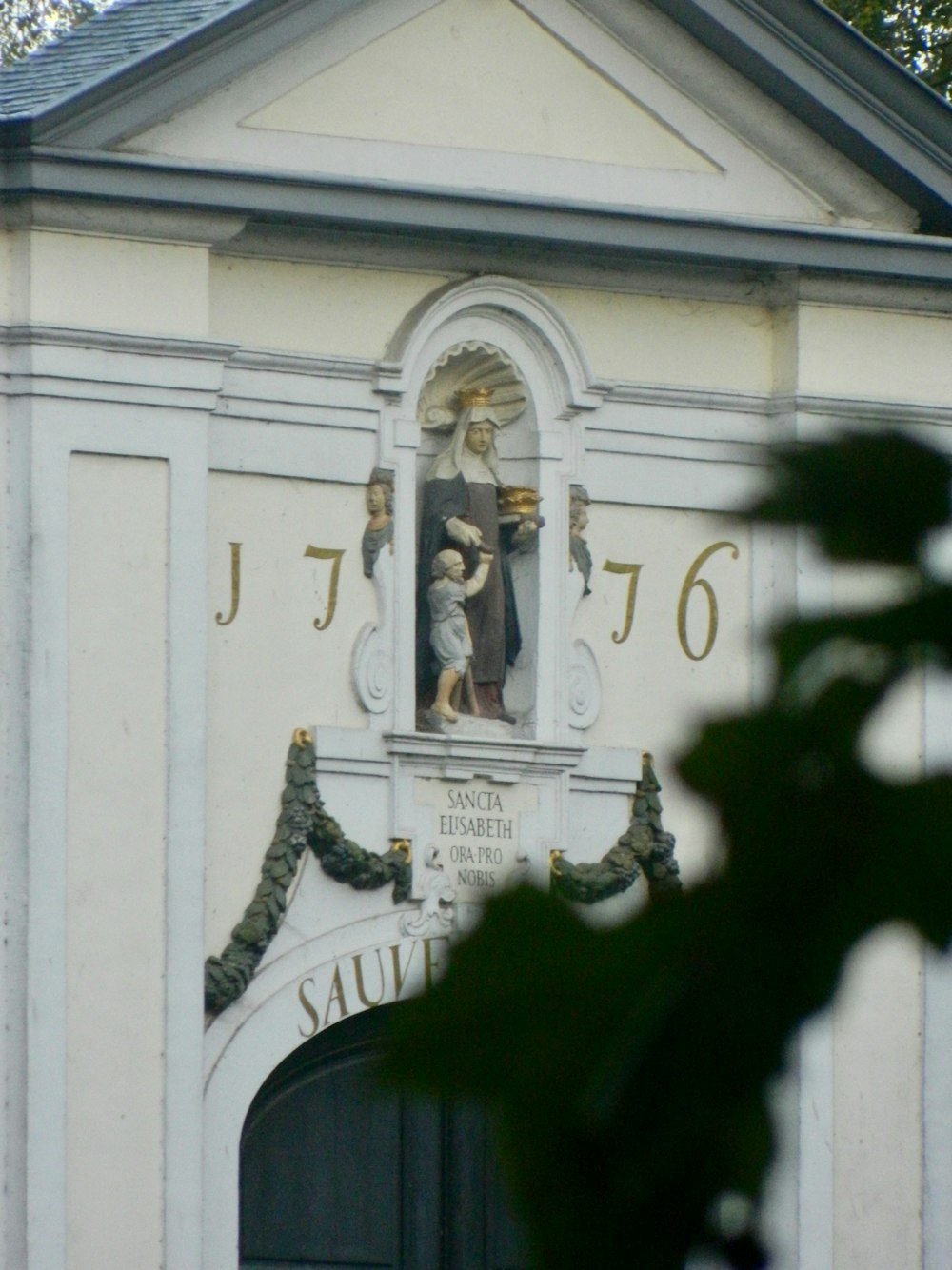 a clock tower with a statue of a woman holding a child