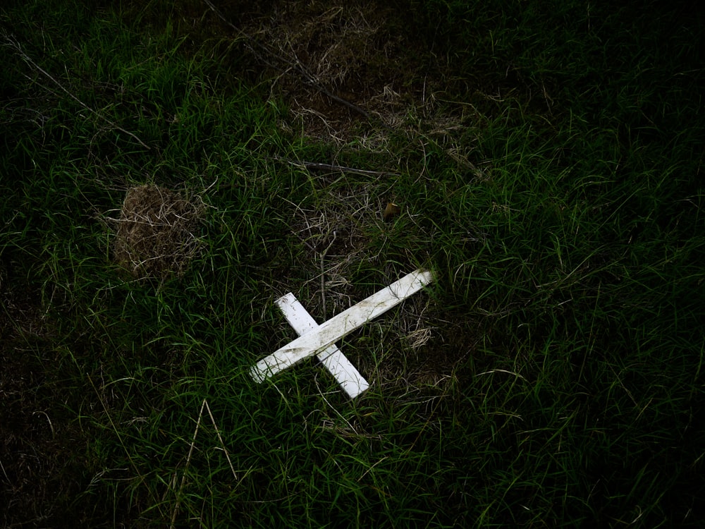 a cross laying on the ground in the grass