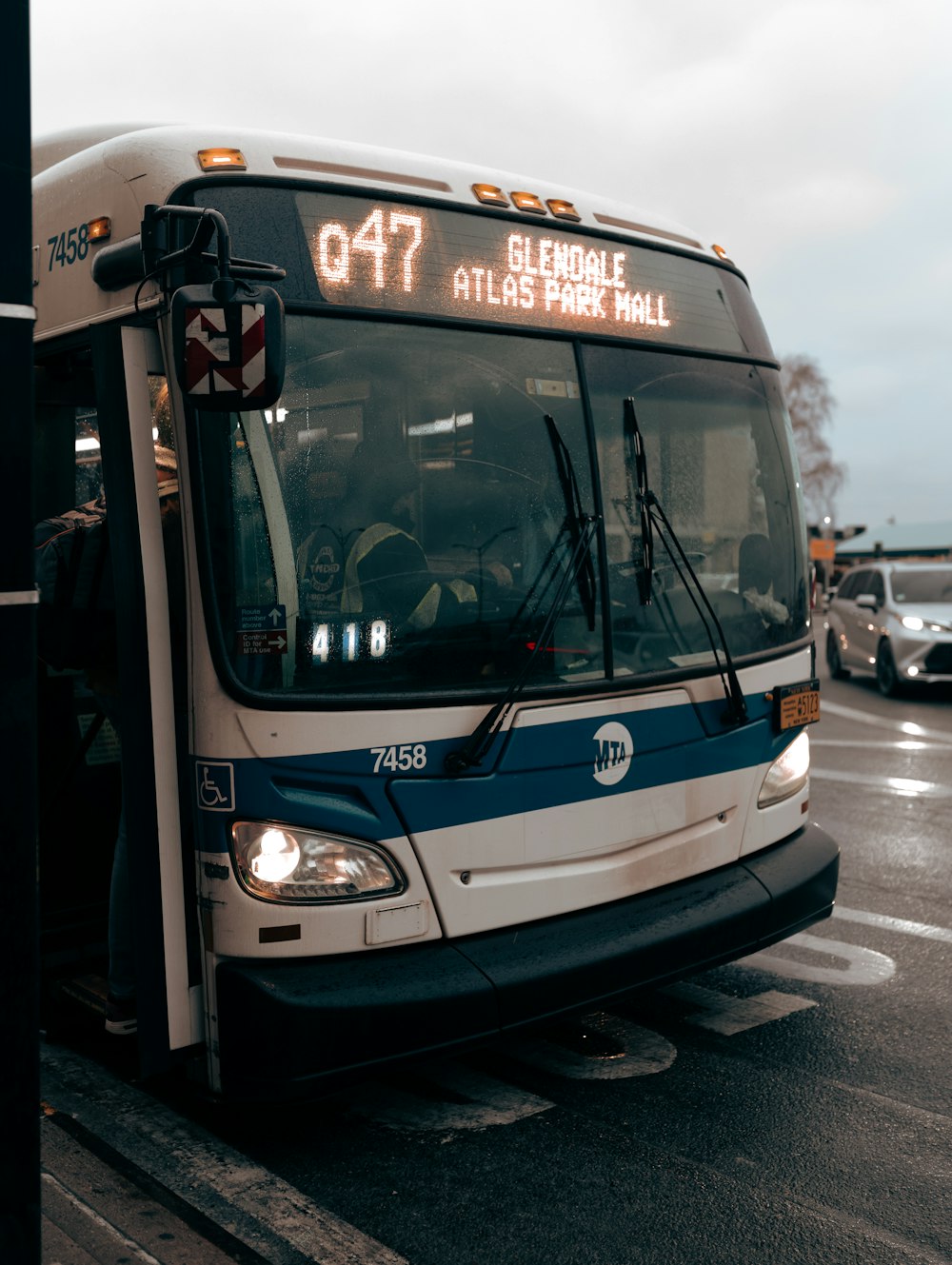 a white and blue bus parked at a bus stop